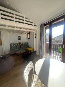 a living room with a couch and a table with chairs at Lovely studio perfect for couples close to beach in Moliets-et-Maa