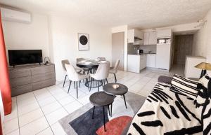 a living room with a dining table and a kitchen at Malibu Village in Canet-en-Roussillon +72 photos