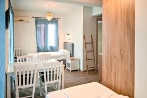 a small room with a table and chairs and a bedroom at Ikaria Studios in Agios Kirykos