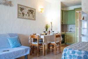 una stanza con tavolo, sedie e cucina di CASA DEL MARINAIO a Porto Ottiolu