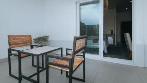 una mesa y sillas sentadas en un balcón con una mesa y una ventana en RedDoorz Premium at Regency Sunset Hotel, en Ángeles