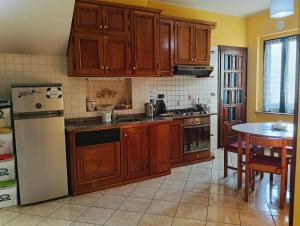 a kitchen with wooden cabinets and a white refrigerator at La Casa di Laura in Ciriè