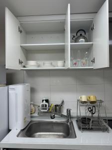a kitchen counter with a sink and a refrigerator at Yongridan-gil House in Seoul +1 photo