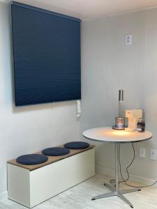 a table with two stools under a table in a room at Yongridan-gil House in Seoul