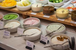 a buffet with bowls of different types of desserts at Rise Urban Art Hotel in Larnaca