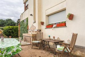 a patio with a table and chairs and a window at Can Mussol in Sant Hilari Sacalm
