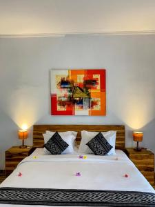 Un dormitorio con una gran cama blanca con dos lámparas. en Green Sunrise Hill View, en Nusa Penida 24 fotos más