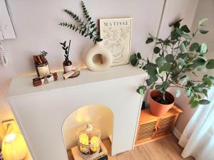a white fireplace with a plant on top of it at 상무하우스 in Gwangju