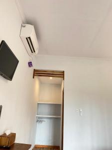 Habitación con TV y armario con estante. en Green Sunrise Hill View, en Nusa Penida
