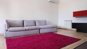 a living room with a couch and a pink rug at Smart and Sea in Tortoreto Lido