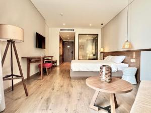 une chambre d'hôtel avec un lit et une table dans l'établissement CONDOTEL APEC Mũi Né, à Ấp Thiẹn Ái