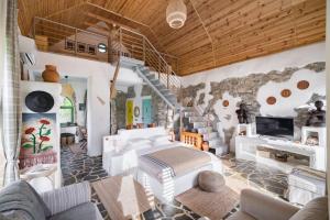 a bedroom with a white bed and a stone wall at Country SPA Village in Ciofliceni