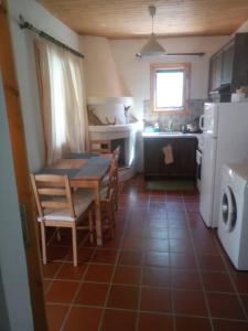 a kitchen with a table and chairs and a refrigerator at Oνειροπαγίδα in Ayia anna