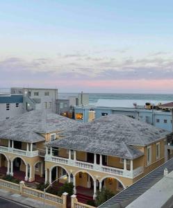 a large white house with a roof at Muizenberg Apartment in Muizenberg
