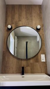 a bathroom with a large mirror over a bath tub at Mikroapartamenty Garden in Oleśnica