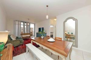 a living room with a table and a couch at Muizenberg Apartment in Muizenberg
