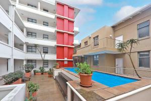 an apartment with a swimming pool in a building at Muizenberg Apartment in Muizenberg