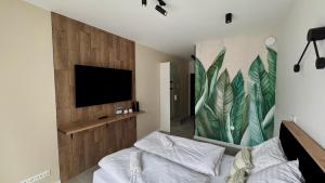 a living room with a bed and a television at Mikroapartamenty Garden in Oleśnica