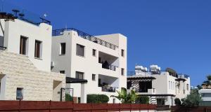 a white building with balconies on the side of it at Othello Apartment with Pool, Balcony, Rooftop Hut Tub & 800 m to sandy beach on foot in Paphos City