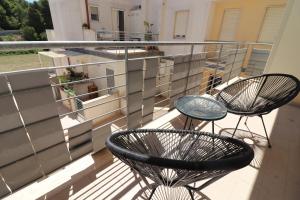 twee stoelen en een tafel op een balkon bij Suite Black and White in Otranto +26 foto's
