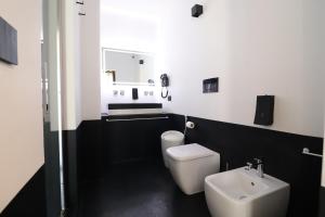 een badkamer met een wit toilet en een wastafel bij Suite Black and White in Otranto