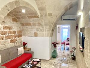 a living room with a couch and a stone wall at Antica Pietra in Polignano a Mare