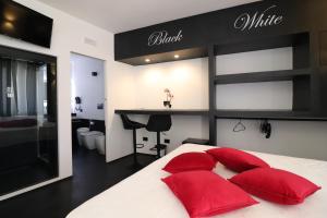een slaapkamer met een groot bed met rode kussens bij Suite Black and White in Otranto