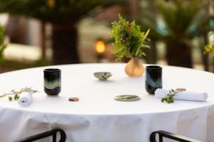 a white table with black cups on top of it at Bella Vista Hôtel, Suites & Maisons in Porticcio