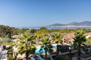 an aerial view of a resort with palm trees at Bella Vista Hôtel, Suites & Maisons in Porticcio