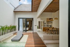 a living room and kitchen with a swimming pool in a house at La Tropical Uluwatu, Bingin in Uluwatu