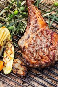 a piece of meat and some vegetables on a grill at Bella Vista Hôtel, Suites & Maisons in Porticcio