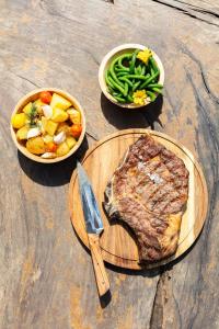 two bowls of food with a steak and a knife at Bella Vista Hôtel, Suites & Maisons in Porticcio