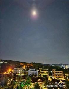 a view of a city at night with the moon at Mi Amor Ocean Penthouse - 3 minutes to the beach - Downtown in Phu Quoc