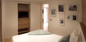 a bedroom with a bed and a tv on a wall at EL DELFÍN VERDE RESORTS - Platja d'Aro in Platja  d'Aro +23 photos