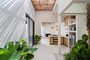 an open kitchen and living room with plants at La Tropical Uluwatu, Bingin in Uluwatu
