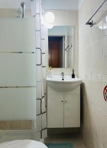 a bathroom with a sink and a toilet and a mirror at Arya Seaview Escape Balcony & Beach Walk in Coral Bay