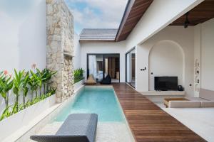 a swimming pool in a villa with a house at La Tropical Uluwatu, Bingin in Uluwatu