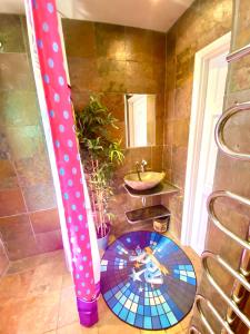 Un baño con lavabo e inodoro en una habitación. en Pop Art Pad heart of Old Town with parking!, en Hastings