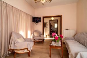 a living room with a couch and a table with flowers on it at Fotini's House Tsagarada Pelion in Tsagarada