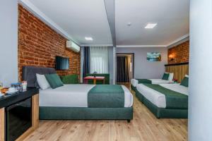 En eller flere senge i et værelse på La Pera Suites