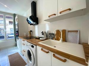 a kitchen with a sink and a washing machine at Vivez le confort moderne pour 4 personnes in Châlons-en-Champagne