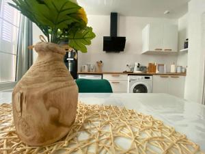 a vase with a plant in it sitting on a table at Vivez le confort moderne pour 4 personnes in Châlons-en-Champagne