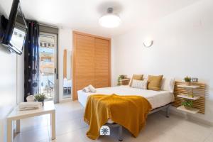 a bedroom with a bed with a yellow blanket on it at Mediterranean Way - Maldivas in La Pineda +38 photos