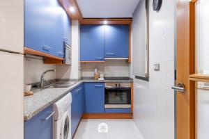 a kitchen with blue cabinets and a sink at Mediterranean Way - Maldivas in La Pineda