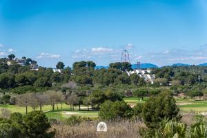 a view of a golf course with a ferris wheel in the background at Mediterranean Way - Maldivas in La Pineda