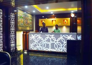 two men standing at a counter in a restaurant at Hotel Orion in Bhadrak