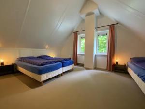 a bedroom with two beds and a window at Bospark Garderen in Garderen