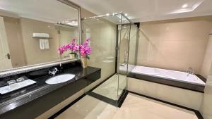 a bathroom with a sink and a tub and a mirror at LK CRYSTAL Ville Pattaya in Pattaya South