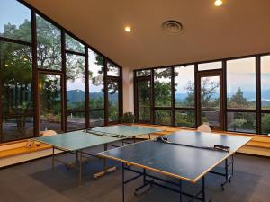 two ping pong tables in a room with windows at Sunset Terrace Ise in Minamiise