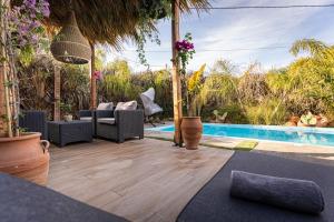 an outdoor patio with chairs and a swimming pool at Hera Elysium Retreat Villas in Kalavárda